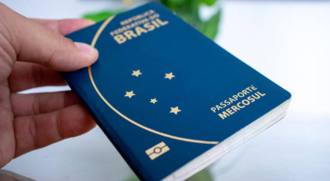 Passaporte brasileiro azul sobre mesa com documentos de viagem — como tirar o passaporte para viajar ao exterior
