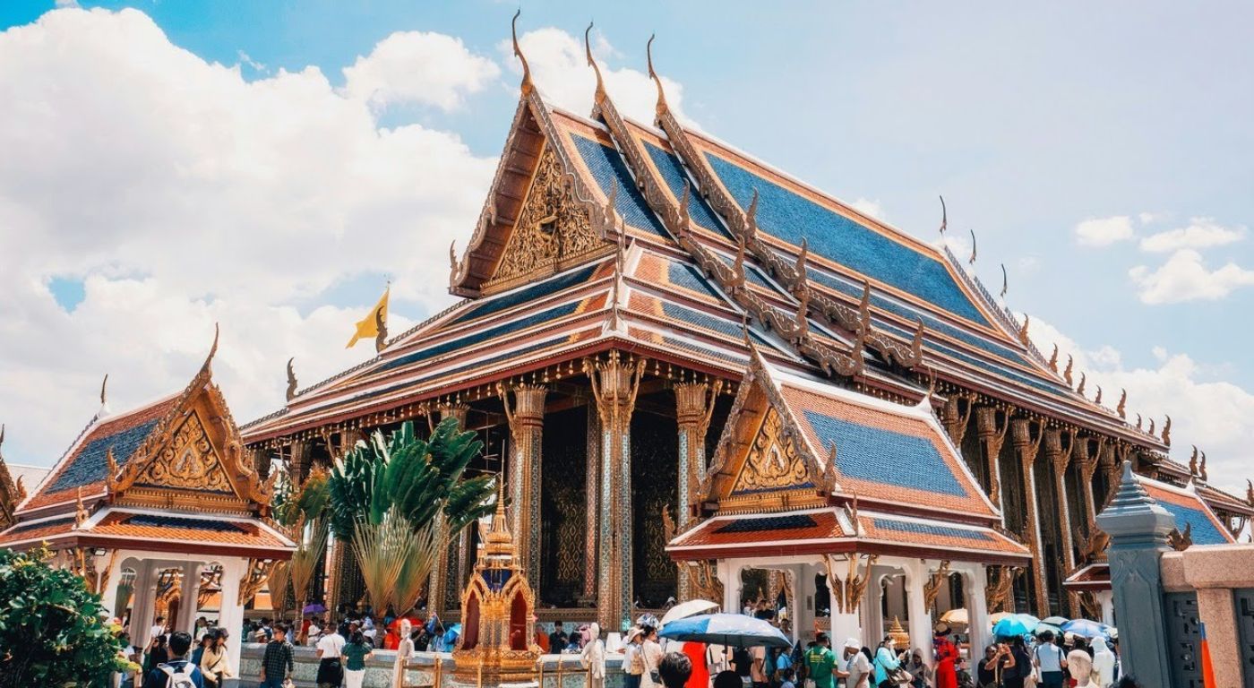Rua movimentada de Bangkok com turistas e templos ao fundo — a Tailândia é um dos destinos mais seguros do Sudeste Asiático